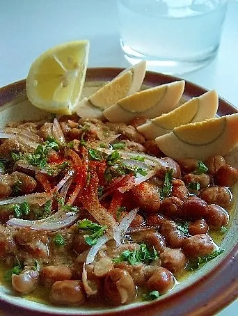 A bowl of koshari, Egypt's national dish, layered with rice, lentils, and crispy onions